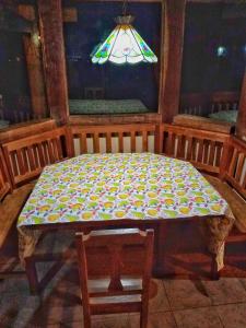 una mesa y una silla en una habitación con lámpara en Peña Alta Samaipata, en Samaipata