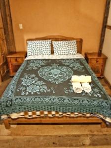 a bedroom with a bed with two slippers on it at Peña Alta Samaipata in Samaipata