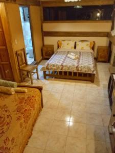 1 dormitorio con 1 cama y 1 silla en Peña Alta Samaipata, en Samaipata