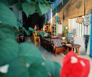 - un salon avec des canapés, des tables et des chaises dans l'établissement Golden Lantern Tam Thanh Homestay, à Tam Kỳ