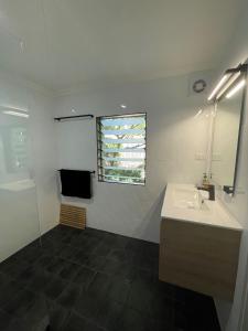 La salle de bains est pourvue d'un lavabo et d'un miroir. dans l'établissement Long Haven, à Iluka