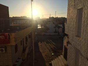 vista di una città con il sole in lontananza di Elephantine Hostel a Aswan