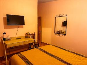 a bedroom with a bed and a desk and a mirror at Casa Esperanza in Panajachel