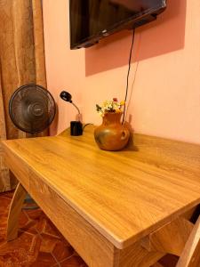 una mesa de madera con un jarrón con flores. en Casa Esperanza en Panajachel