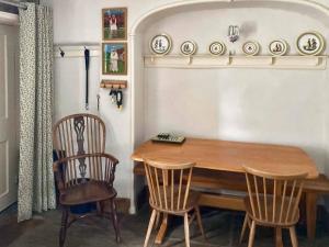 einen Esstisch mit 2 Stühlen und einem Holztisch in der Unterkunft Spoutscroft Cottage in Austwick