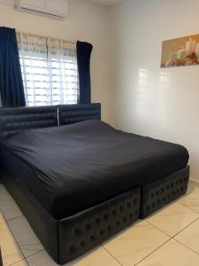 a black bed in a room with a window at Luxe appartementen Paramaribo Noord in Paramaribo