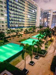 an overhead view of a pool with palm trees and buildings at Madison Place at Sea Residences powered by Cocotel in Manila