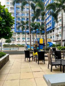 a patio with chairs and tables in front of a building at Madison Place at Sea Residences powered by Cocotel in Manila