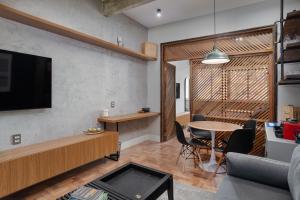 een woonkamer met een tv en een tafel en stoelen bij Studio na quadra da praia de Copacabana in Rio de Janeiro