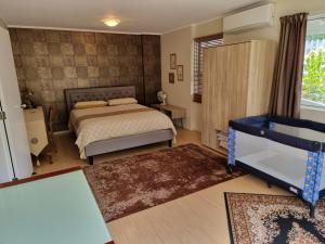 a bedroom with a bed and a table and a window at Entire ground floor with full-privacy and family-friendly popular to ferry catchers in Wellington