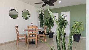 ein Esszimmer mit einem Tisch, Stühlen und Pflanzen in der Unterkunft Best Western Riviera Tuxpan in Tuxpan de Rodríguez Cano