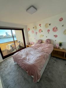 a bedroom with a bed with flowers on the wall at Perfect in the centre with view in London