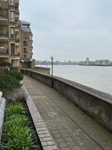 a sidewalk next to a body of water with buildings at Perfect in the centre with view in London