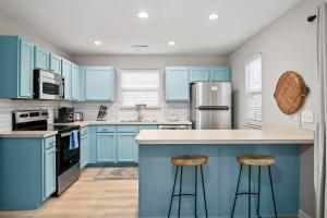 eine blaue Küche mit blauen Schränken und Barhockern in der Unterkunft Boho SoCo- 8 mins to Credit One 20 mins to DTWN in Charleston