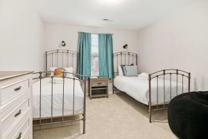 a bedroom with two twin beds and a window at Boho SoCo- 8 mins to Credit One 20 mins to DTWN in Charleston