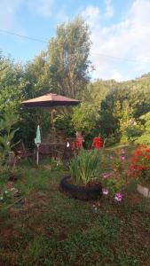 einen Garten mit einem Tisch, einem Sonnenschirm und Blumen in der Unterkunft Cabaña Frente Al mar, Carretera Austral km 38,6, Puerto Montt in Puerto Montt