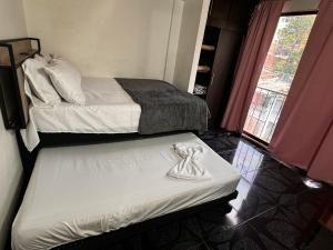 Pokój hotelowy z 2 łóżkami i ręcznikiem na łóżku w obiekcie Aparta Suite Torre De Prado 401 w mieście Medellín