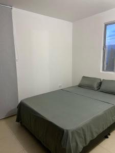 Bett in einem weißen Zimmer mit Fenster in der Unterkunft Apartamento en Prados del Este Amplio comodo y equipado in Cúcuta