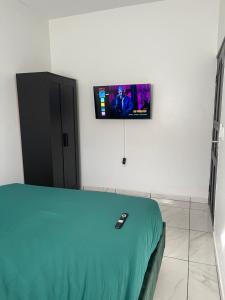 a room with a bed with a tv on the wall at Luxe appartementen Paramaribo Noord in Paramaribo