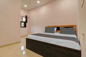Tempat tidur dalam kamar di Capital O Hotel Peeragarhi Near M2K Cinemas Rohini