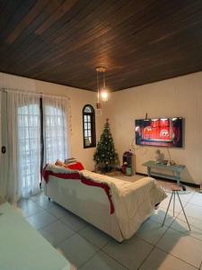 um quarto com uma árvore de Natal e uma cama grande em Lar Pôr-do-Sol do Sambaqui em Florianópolis