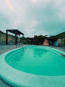 une grande piscine bleue dans une cour dans l'établissement Lar Pôr-do-Sol do Sambaqui, à Florianópolis