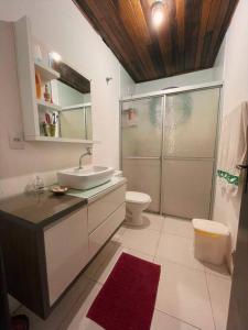 uma casa de banho com um lavatório, um chuveiro e um WC. em Lar Pôr-do-Sol do Sambaqui em Florianópolis