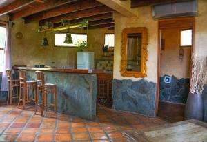 a kitchen with a counter and stools in a room at Hotel Boruca Tamarindo in Tamarindo