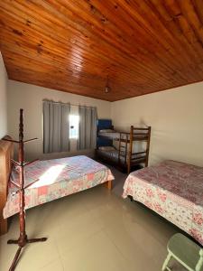 - une chambre avec deux lits et un plafond en bois dans l'établissement Chácara Gama em condomínio Igarata-SP - Jacuzzi com hidromassagem, piscina e sauna, à Igaratá