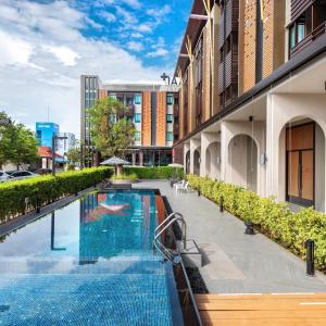 羅勇的住宿－PLAAI Plus Hotel Rayong，建筑物一侧的游泳池