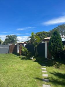 a yard with a fence and a lawn with a pathway at Chácara Gama em condomínio Igarata-SP - Jacuzzi com hidromassagem, piscina e sauna in Igaratá
