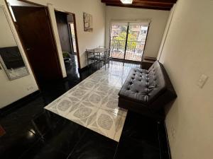 a living room with a leather chair in a room at Aparta Suite Torre De Prado 501 in Medellín