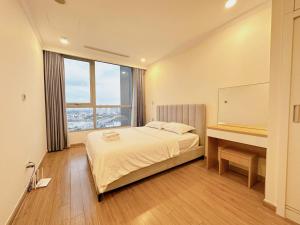 a bedroom with a bed and a desk and a window at 2 Bedrooms in Landmark area in Ho Chi Minh City