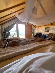 a large bed in a room with a large window at Live the bedouinlife in Nuweiba