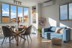 uma sala de estar com uma mesa e um sofá azul em Penthouse , Sea View @ Roof Top , 4 Min to Beach em Santa Pola