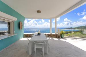 a dining room with a table and views of the ocean at Oceanview Luxury Villa Escape in Dawn Beach
