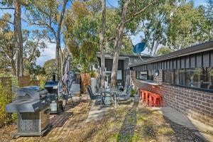 a backyard with a brick house and a grill at The Bunker - Orange, NSW in Mullion Creek