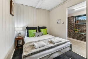 a bedroom with a bed and a brick wall at The Bunker - Orange, NSW in Mullion Creek