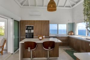 a kitchen with a large island with two bar stools at Oceanview Luxury Villa Escape in Dawn Beach
