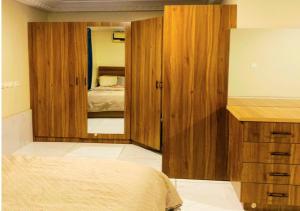 ein Schlafzimmer mit einem Bett und einem großen Spiegel in der Unterkunft Salma's Place 