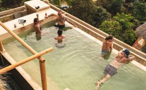 een groep mensen in een zwembad bij Villa Macarena Apartamentos Boutique - Adults Only in Puerto Escondido
