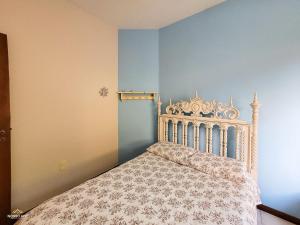 1 dormitorio con cama y pared azul en Nosso Apê Enseada: Casa na Represa João Penido com Wifi, Piscina e Churrasqueira, en Juiz de Fora
