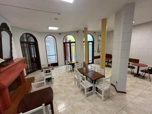 een kamer met een tafel, stoelen en ramen bij Recreo Beach in Huanchaco
