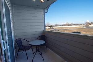 een veranda met 2 stoelen, een tafel en een raam bij Caldwell Cliff Swallow Guest House in Caldwell