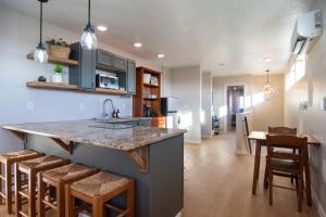 a kitchen with a counter and a kitchen island with bar stools at Caldwell Cliff Swallow Guest House in Caldwell