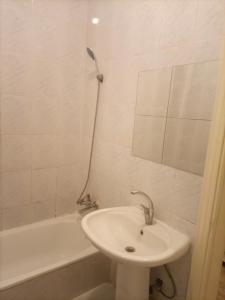 a white bathroom with a sink and a bath tub at Andalius1 in Irbid