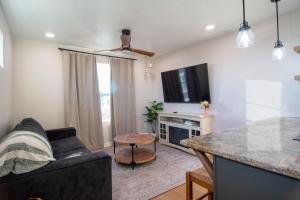 a living room with a couch and a tv at Caldwell Cliff Swallow Guest House in Caldwell