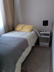 um quarto com uma cama com uma almofada e uma mesa em Departamento Ovalle 305 Quipu em Ovalle