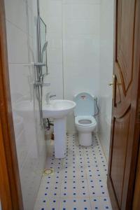 ein weißes Bad mit einem WC und einem Waschbecken in der Unterkunft Résidence Good House in Dakar
