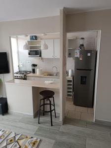 uma cozinha com um frigorífico e um banco em Departamento Ovalle 305 Quipu em Ovalle